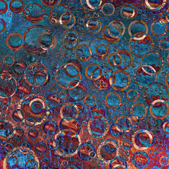 Multi-colored rings and their reflections are located on a red-blue background. Abstract abstraction