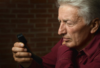Portrait of happy senior man with phone