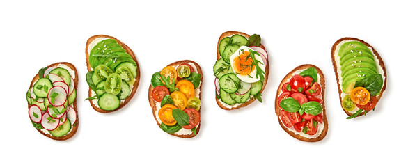Open sandwiches with avocado, cherry tomato, cucumber, radish. Italian vegan bruschetta with soft cheese. Various sandwich with basil isolated on white background, top view. Flat lay