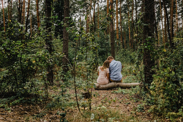 Naklejka na ściany i meble Сouple in love sits in the forest