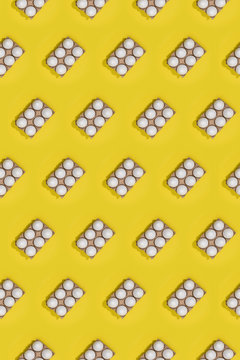 Bright seamless Easter template with white eggs in carton boxes on yellow background