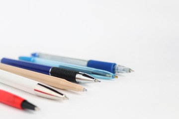 Pens of different colors and sizes on a white background