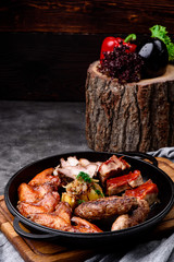 Baked meat in a pan on a concrete background. Beer snack. Close-up. Space for text