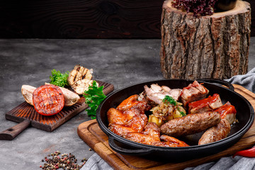 Baked meat in a pan on a concrete background. Beer snack. Close-up. Space for text