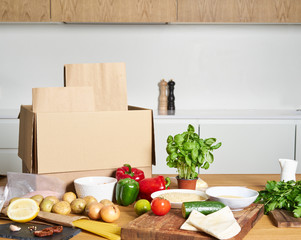 Box with packed meat vegetables on kitchen background. Food delivery services during coronavirus pandemic and social distancing. Shopping online. .Dinner delivery service.