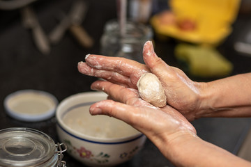 woman hands making balls out of the dough at the kitchen
