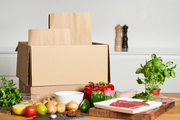 Box with packed meat vegetables on kitchen background. Food delivery services during coronavirus pandemic and social distancing. Shopping online. .Dinner delivery service. - 342089394