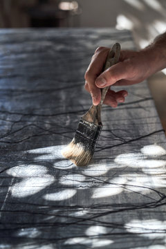 Unrecognizable artist drawing with big paintbrush
