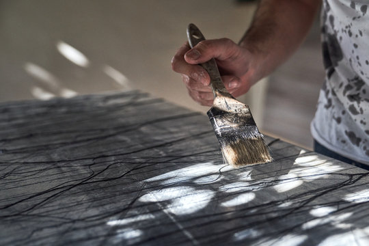 Unrecognizable artist drawing with big paintbrush