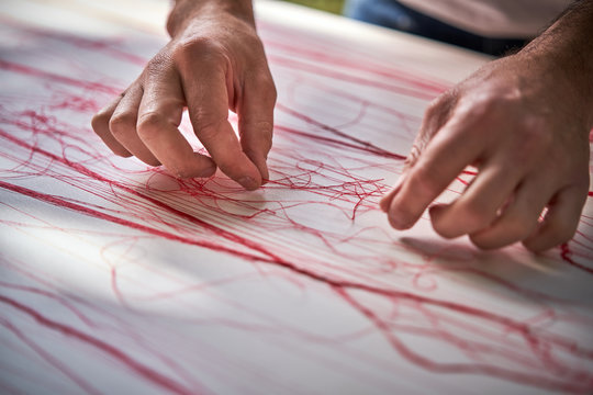 Male artisan working with threads in workshop