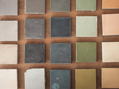 Top view of square samples of handmade tiles pf beautiful cold and warm shades on wooden floor