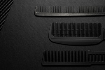 On a black surface are old barber tools. barber tools. four comb. black monochrome. frame. top view.