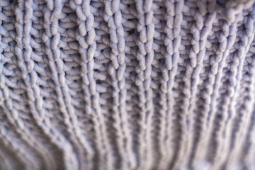 Background or texture of blue hand-knitted plaid and pillows in cosy autumn or winter home.