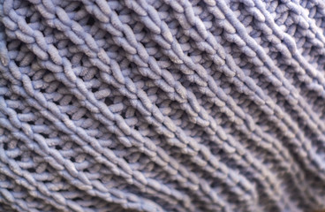 Background or texture of blue hand-knitted plaid and pillows in cosy autumn or winter home.