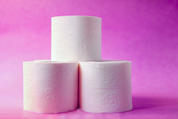 Soft, white toilet paper roll on pink pastel bright background. Hygiene concept. Empty place for text, object or logo.