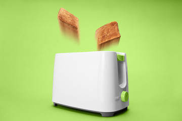 Motion blurred Toast bread jumping out of white toaster on avocado green background
