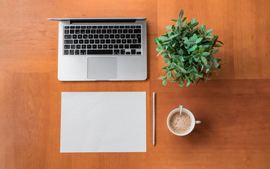 Workspace with laptop, cup of coffee, blank paper and pencil