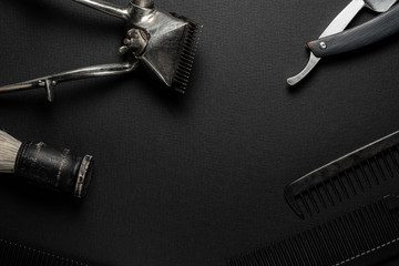 On a black surface are old hairdresser tools. vintage hand-held hair clipper, hairdressing...