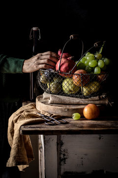 Crop senior person taking fruit from basket