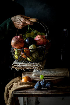 Crop senior person taking fruit from basket