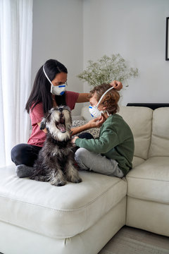 Mother putting on a respirator for her child to avoid possible infection