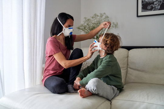 Mother putting on a respirator for her child to avoid possible infection