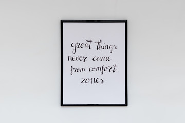 Quote "great things never came from comfort zones", handwritten in a frame