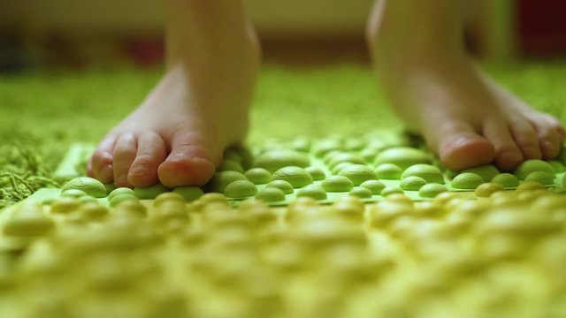 foot massage, the child steps on a barefoot massage mat, close-up