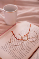 glasses with open book. Cup of coffee