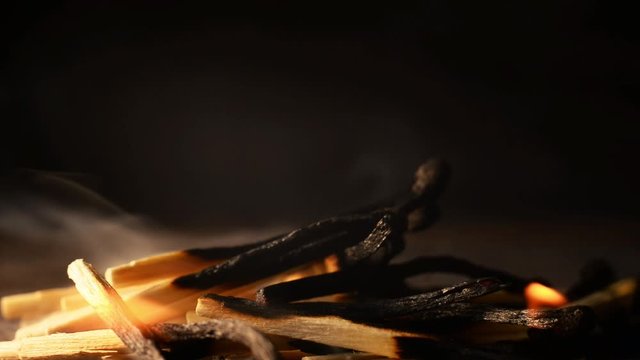 Burning match. A closeup of a pile of matches burning. Tongues of flame and smoke on a dark background. fireplace