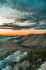 Industrial landscape with sunset sky over kaolin mining site in Hlukhivtsi, Ukraine