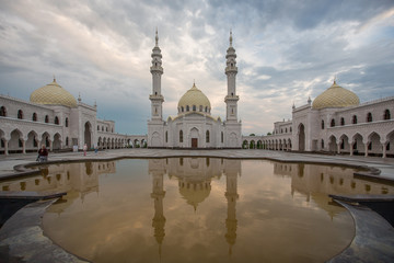 Naklejka premium A beautiful white mosque in the city of Bulgarians is reflected in the water against the backdrop of a beautiful sky, without people