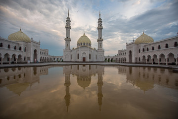 A beautiful white mosque in the city of Bulgarians is reflected in the water against the backdrop of a beautiful sky, without people