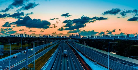 dawn highway traffic miami florida buildings horizon landscape sky clouds circulation dusk highway bridge lighting auto transportation acceleration urban impressions dusk