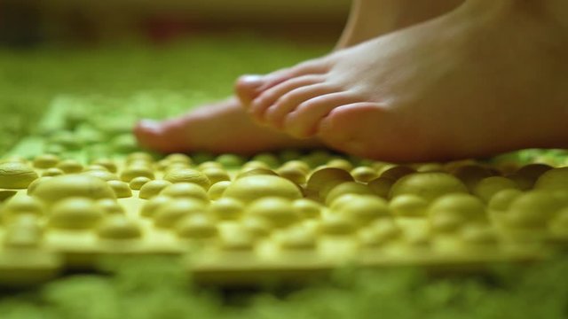 foot massage, the child steps on a barefoot massage mat, close-up