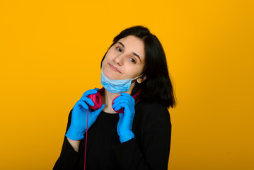 The caucasian girl in blue colored protective face mask. The girl looking at camera. Portrait shot over pink background. virus and pollution protection concept.