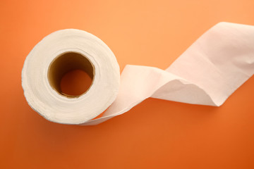 close up of roll of toilet paper on orange background 