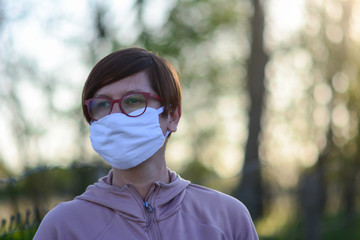 Portrait of attractive woman with handmade mask on her face to protect herself from coronavirus pandemic. Home made handicraft protective mask against covid 19 virus.