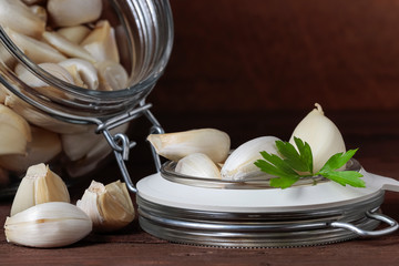 glass airtight jar with garlic cloves and parsley