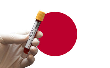 COVID-19 Pandemic Coronavirus concept ; Close-up of a Positive COVID-19 blood test sample tube with Japanese Flag at background. Blood testing for diagnosis new Corona virus infection.