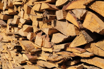 texture of pine firewood. Chipped firewood is on the heap. Woodpile of firewood close-up. A stack of dry firewood, visible texture and cracks in the tree. selective focus.