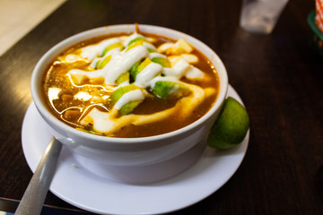 Mexican food dish, recipe for "tortilla soup" accompanied by a lot of avocado, cream and cheese