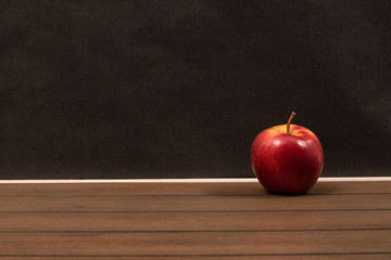Red apple isolated on a wooden table and black background
