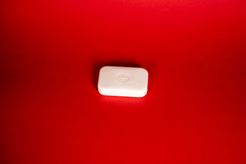 Soap bar in foam with copy space in center isolated on bright red background.