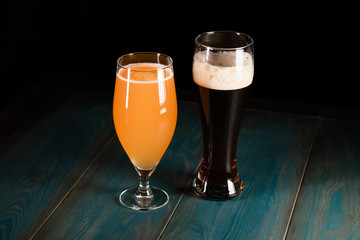 Poured beer on a dark background on a wooden table. The concept of relaxation and pastime