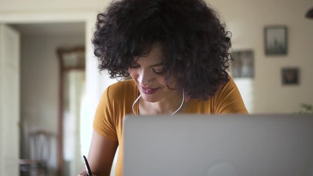 pretty young black girl college student listening to online lesson and writing notes in notebook Spbd. woman remote online education learning. chatting talking with tutor. quarantine