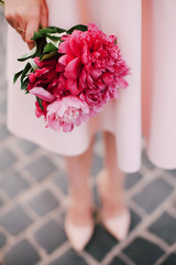 girl with peonies in hands. girl in a pink dress with a bouquet.