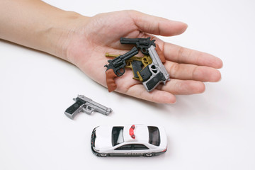 Model police car with tiny model many types of gun in hand on white background, No Have Victim and Violence 