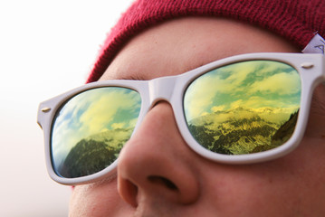 Mountains reflected in sunglasses of the traveler
