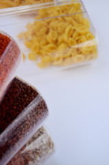 jars with buckwheat oatmeal and pasta on a white background